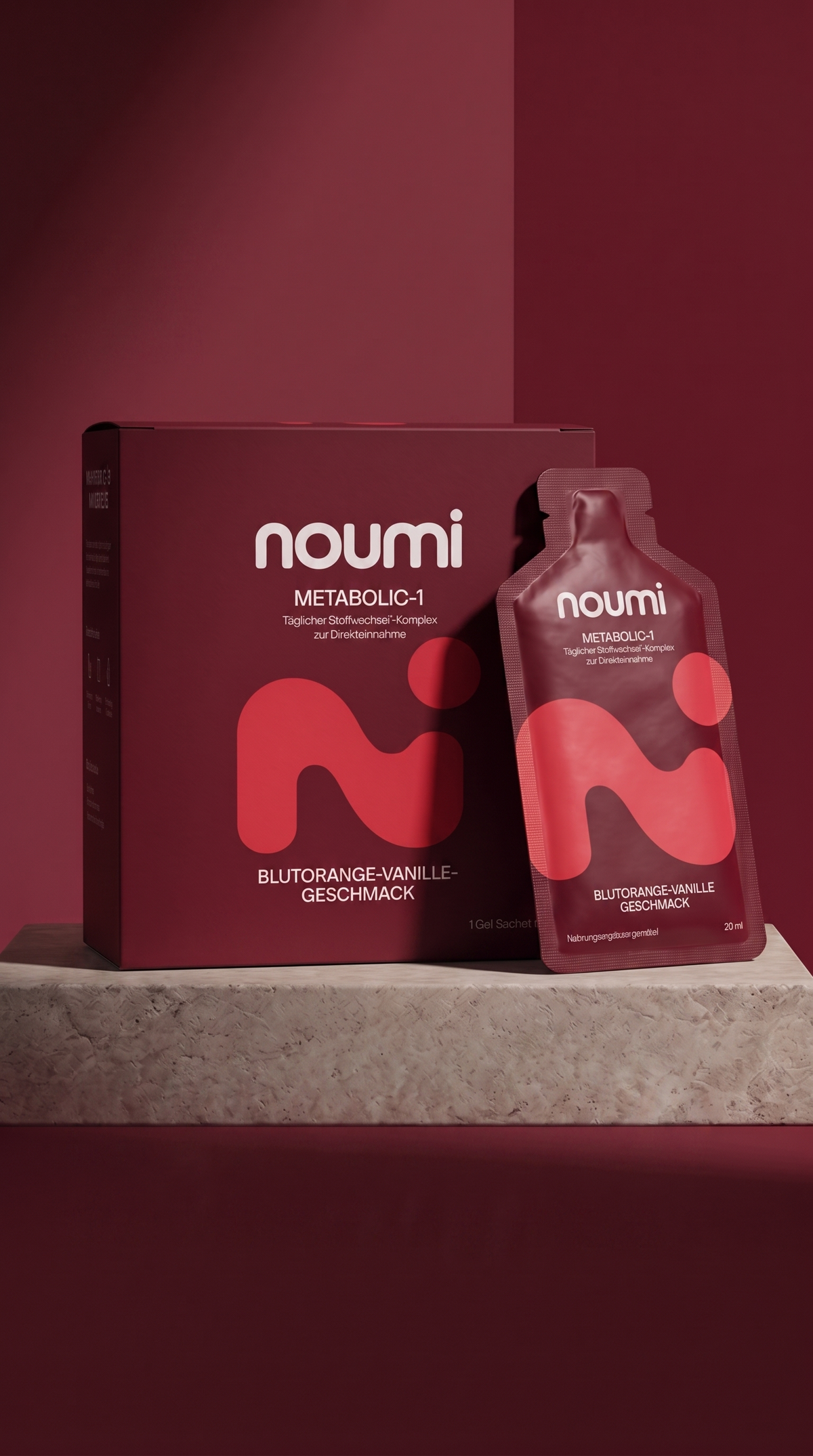 noumi Metabolic-1 Box und Gel-Sachet mit Blutorange-Vanille-Geschmack auf Steinsockel